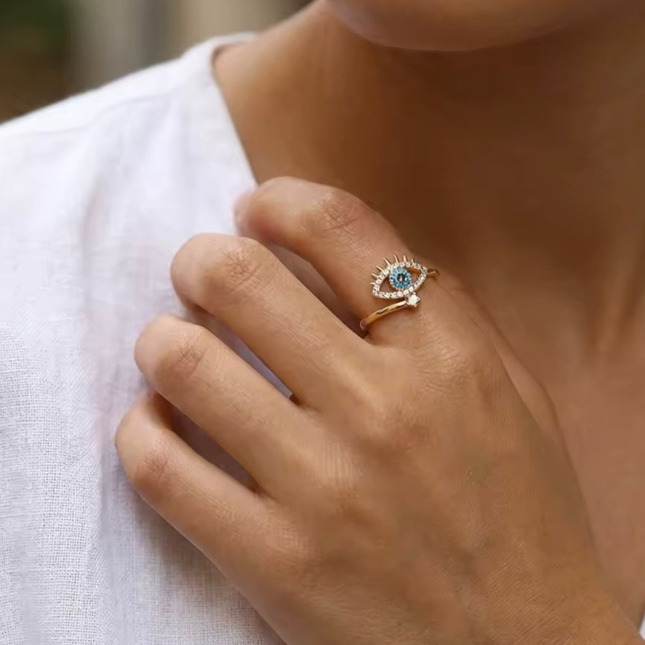 Woman wearing the All Seeing Eye Ring featuring a turquoise evil eye and sparkling crystal accents.