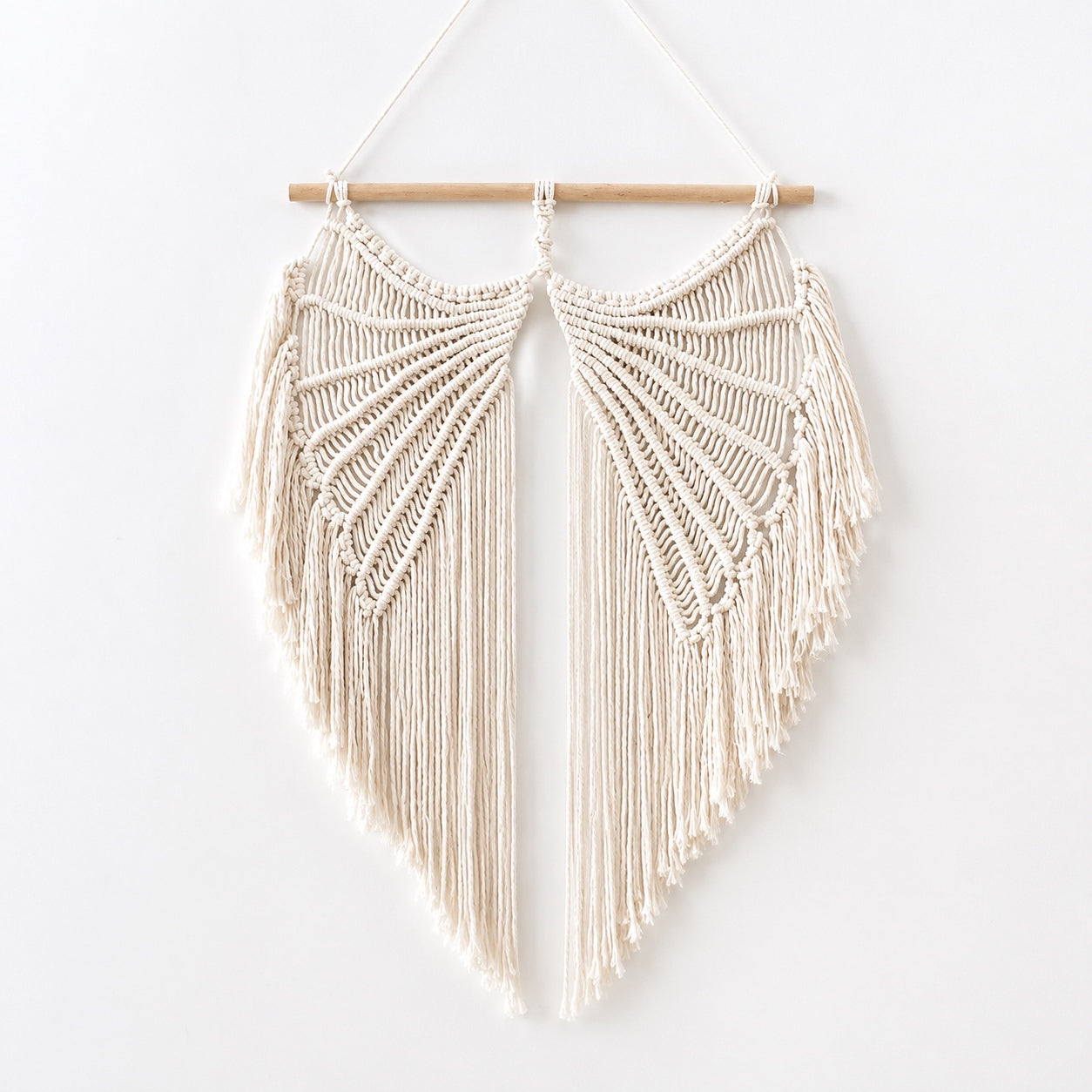 Handcrafted Angel Wings Macrame Wall Hanging made from natural cotton cord with a wooden dowel, shown on a white background.