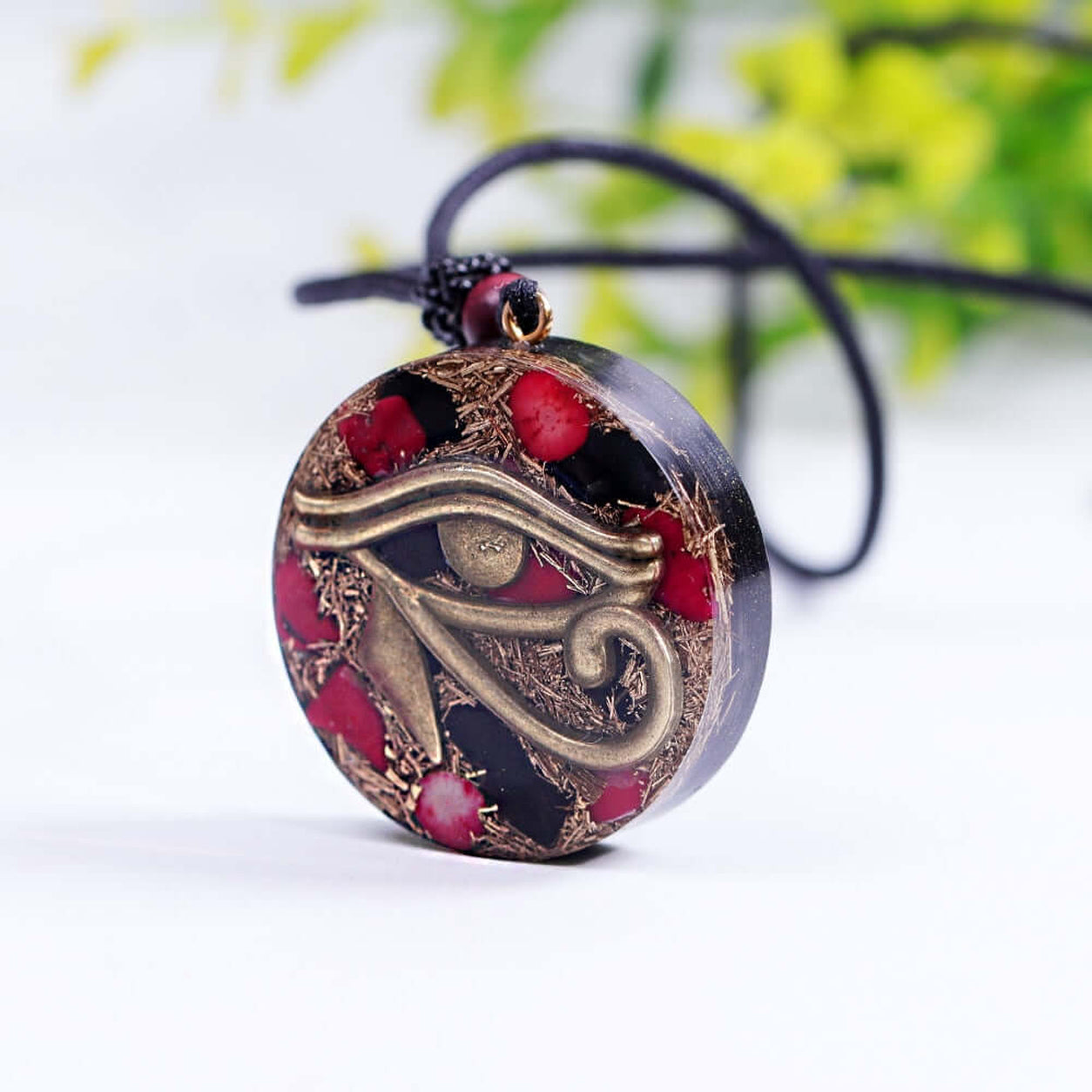 Angled view of the Eye Of Horus Pendant Necklace showing handcrafted resin pendant with bronze Eye of Horus design and red coral accents.