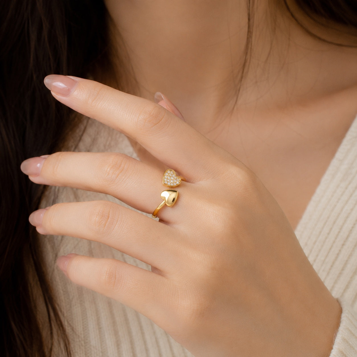 Model wearing the Hearts Of Gold Ring, an adjustable gold heart ring with sparkling crystal accents.