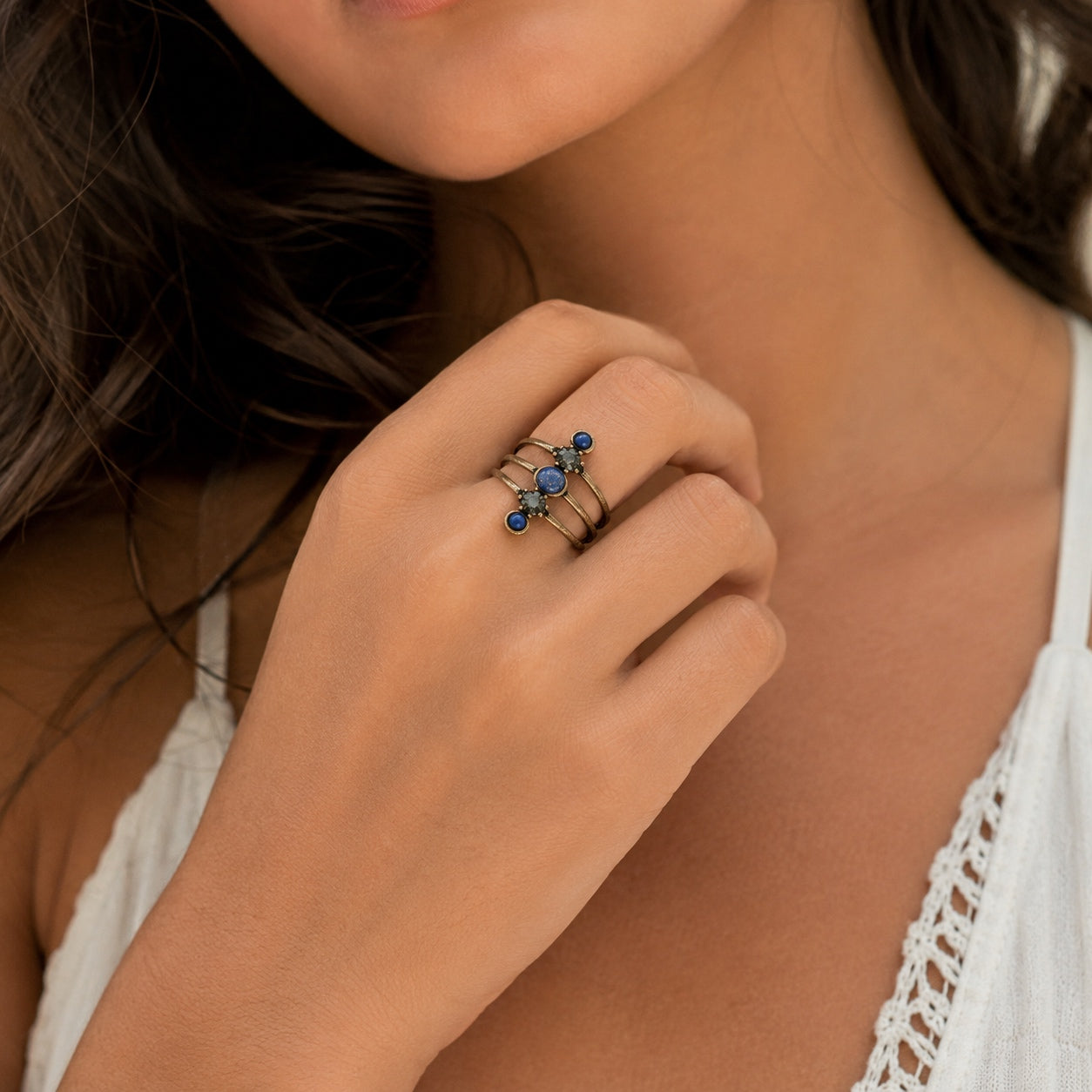 Woman wearing the Lapis Lazuli Stone Ring with an antique bronze finish, deep blue lapis lazuli stones, and crystal accents.