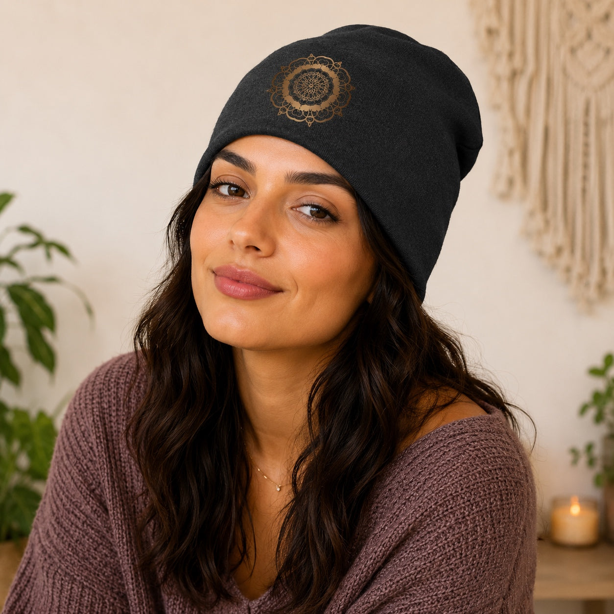 Woman wearing the charcoal gray Mandala Beanie Hat with a bronze mandala print in a cozy indoor setting.