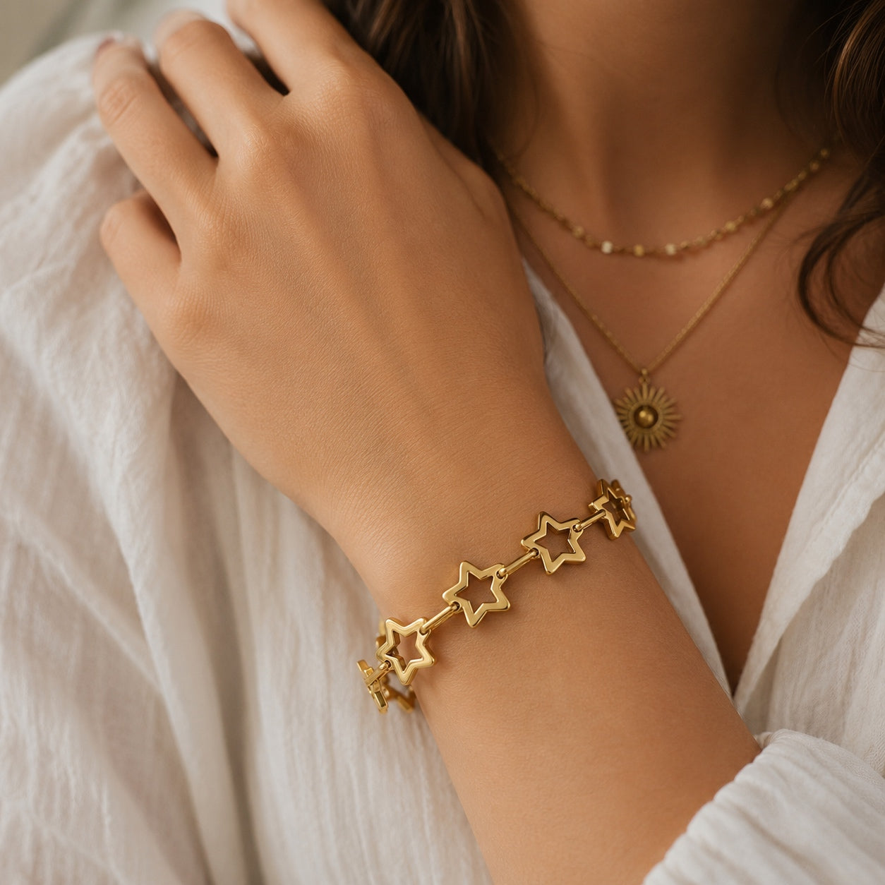 Woman wearing the gold Star Link Chain Bracelet with polished hollow star links.