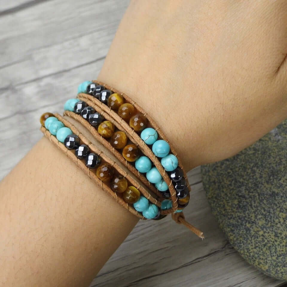 Woman wearing the Spirit Of The West Bracelet, a boho western leather wrap bracelet with turquoise, tiger eye and hematite beads.