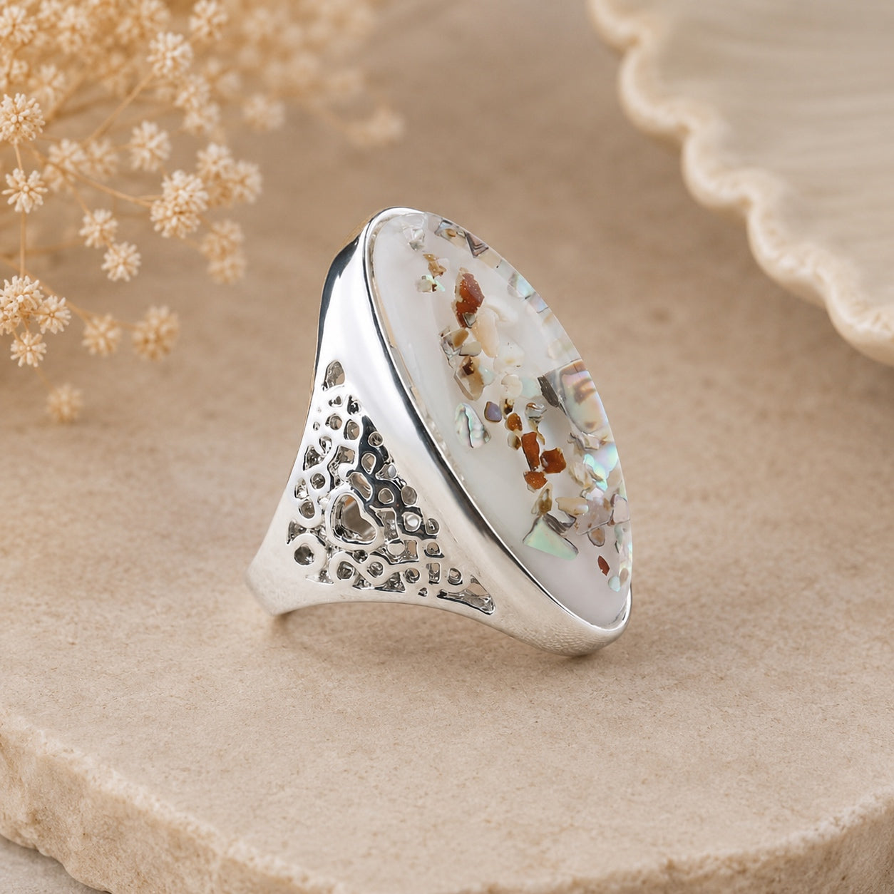 Side view of Abalone Shell Statement Ring featuring an intricate silver band and oval abalone shell centerpiece.