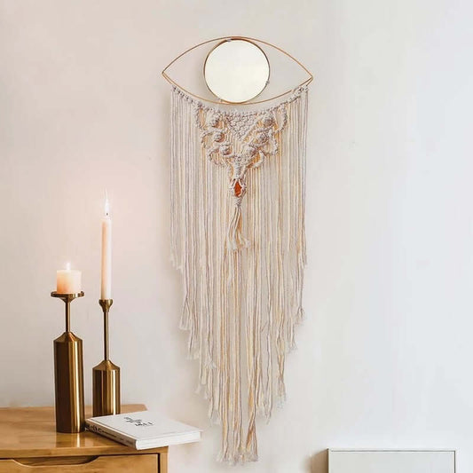 All Seeing Eye Macrame Wall Hanging with intricate cream macrame, a gold eye frame, and cascading fringe displayed on a minimalist wall.