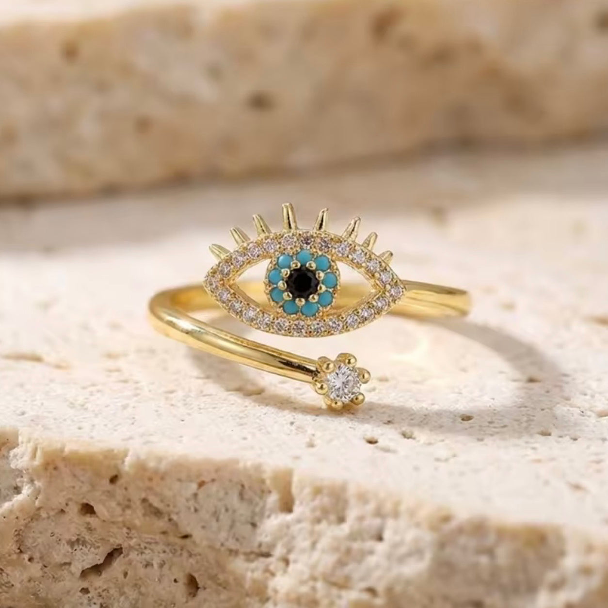     All Seeing Eye Ring featuring a turquoise evil eye design with shimmering crystals and an adjustable open band.