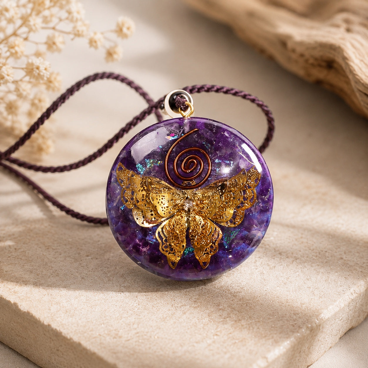 Amethyst Butterfly Pendant Necklace displayed on a natural stone surface featuring a genuine amethyst crystal, gold butterfly centerpiece, and adjustable braided cord.