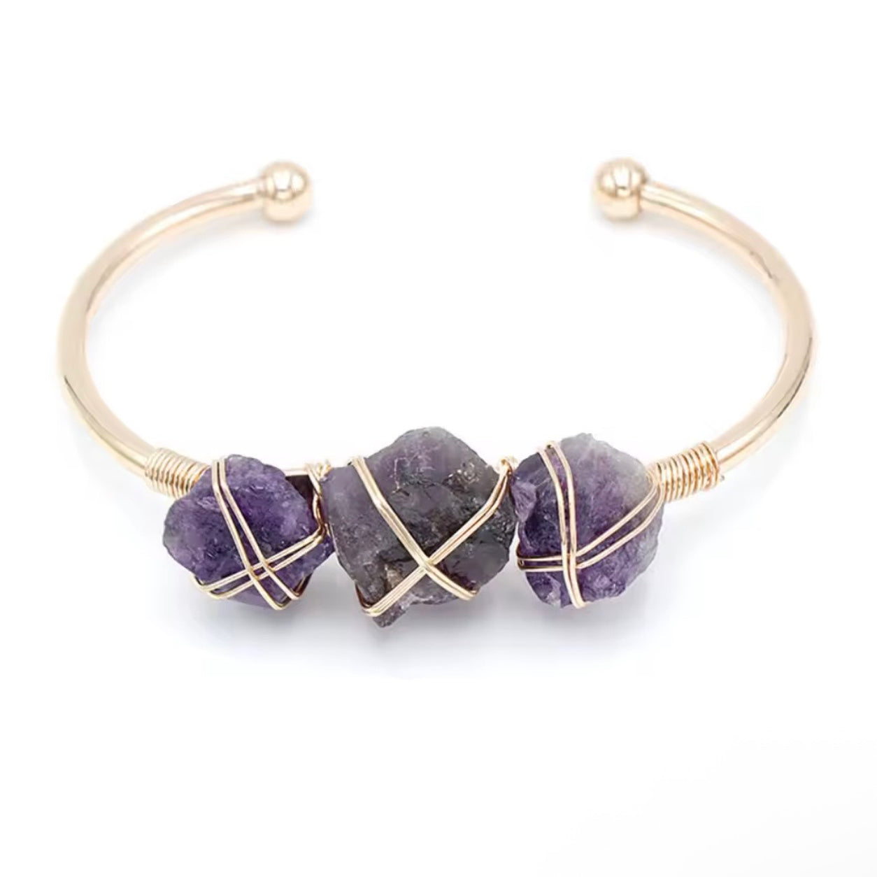 Amethyst stone cuff bracelet featuring three raw purple crystals and gold-tone wire wrapping.