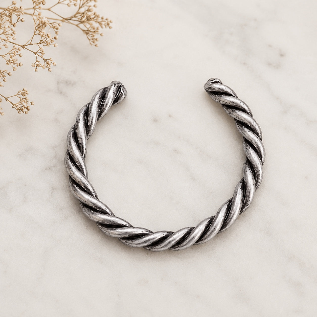 Antique Silver Coil Cuff Bracelet on a marble display with a rustic boho jewelry styling.