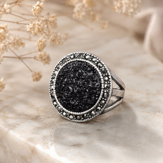 Black Druzy Statement Ring with sparkling black druzy stone and vintage silver setting displayed on a marble surface.