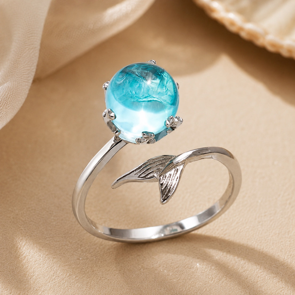 Close-up of the Blue Crystal Mermaid Ring showcasing a sparkling blue crystal and polished silver mermaid tail setting.