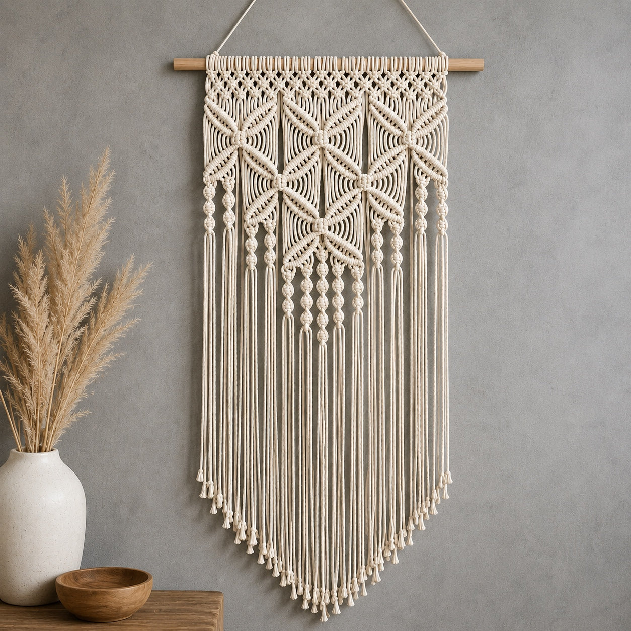Bohemian Nature Macrame Wall Hanging displayed on a textured gray wall with pampas grass and neutral boho decor.