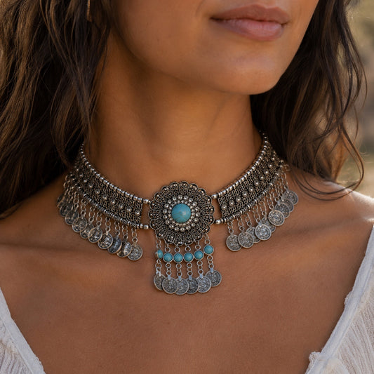Woman wearing the Bohemian Turquoise Collar Necklace featuring turquoise stones, vintage silver detailing and dangling coin charms.