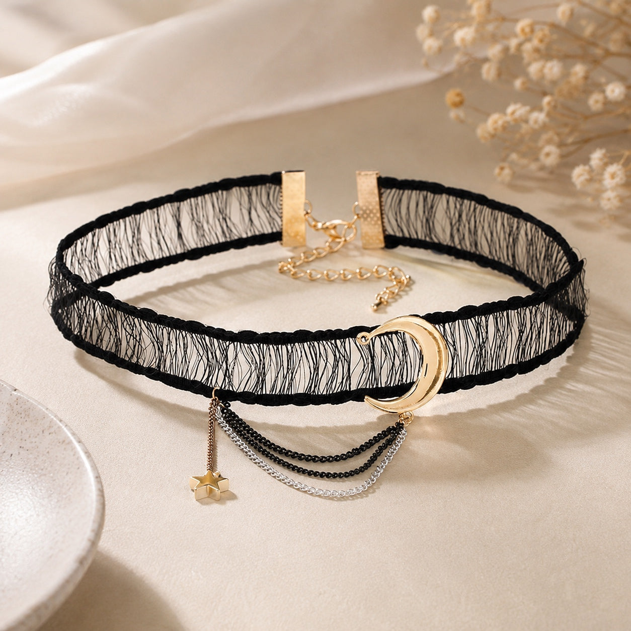 Celestial Lace Choker Necklace with black lace, gold crescent moon pendant, silver layered chains, gold star charm, and adjustable clasp displayed on a soft neutral background.