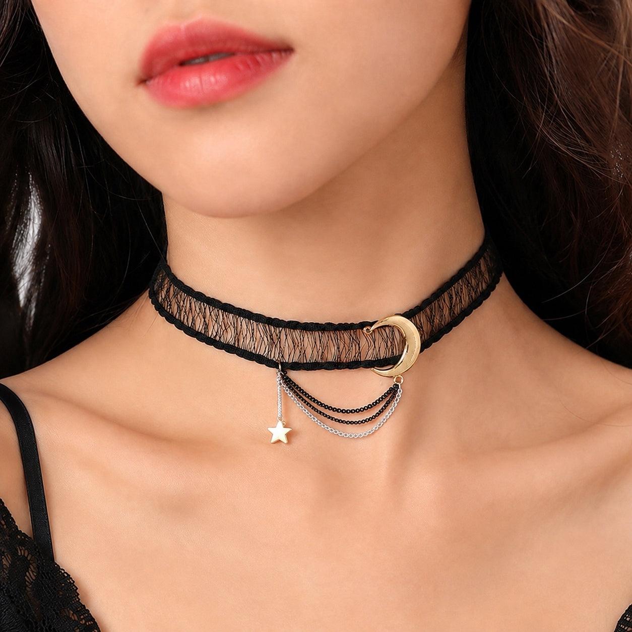 Close-up of a woman wearing the Celestial Lace Choker Necklace featuring a black lace choker with a gold crescent moon, silver draped chains, and a dangling gold star charm.
