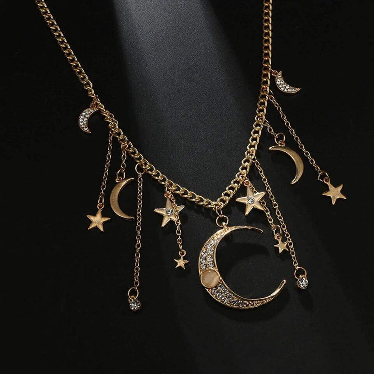 Close up view of gold celestial necklace with moon and star charms