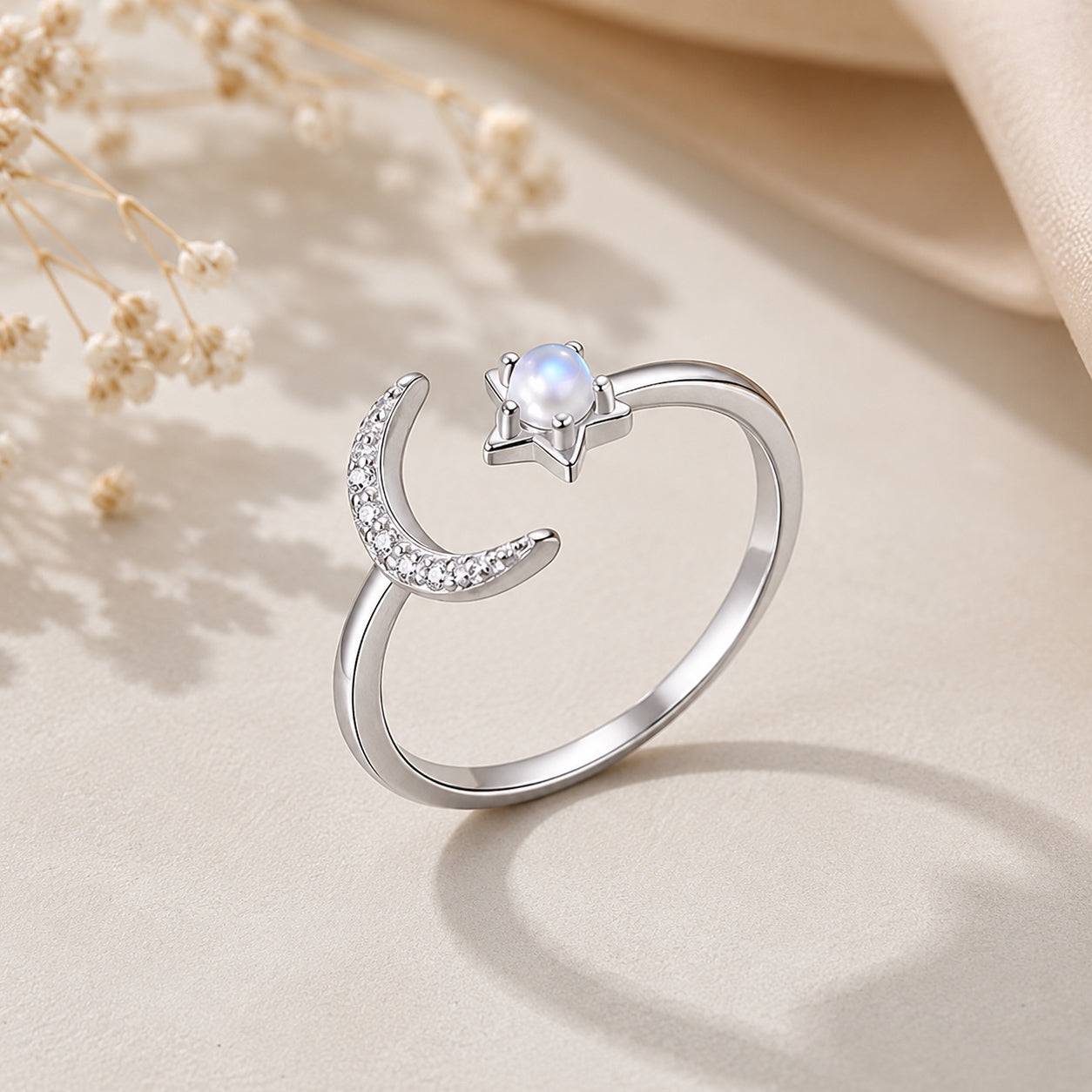 Celestial Moonstone Ring in sterling silver with a crescent moon, moonstone, and star accent on a soft neutral background.