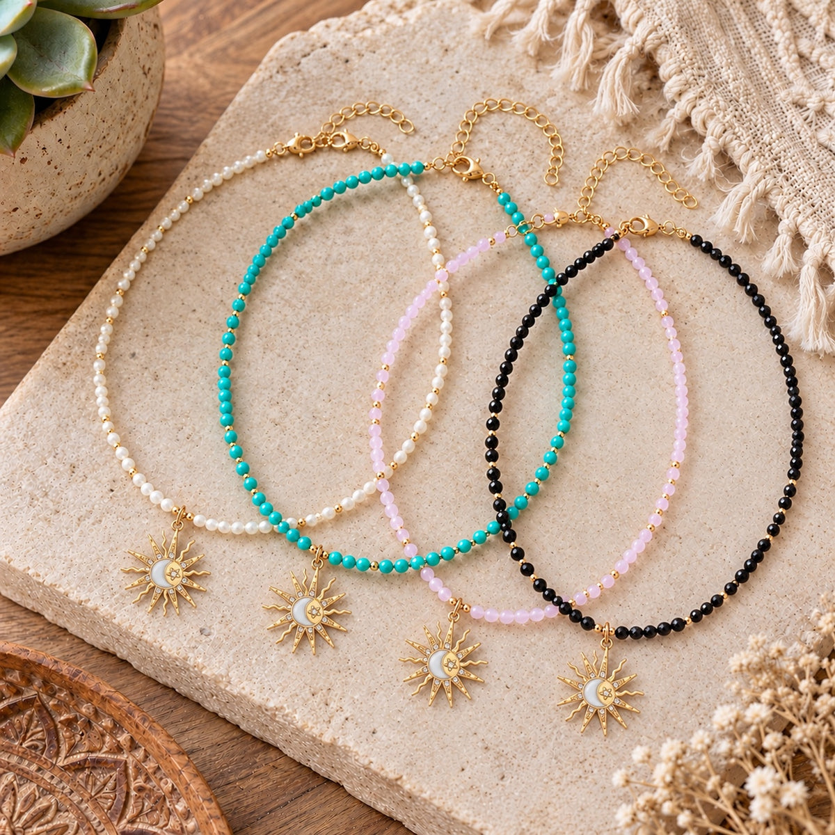 Four celestial sun pendant necklaces in white, turquoise, pink and black beads with gold-tone accents.