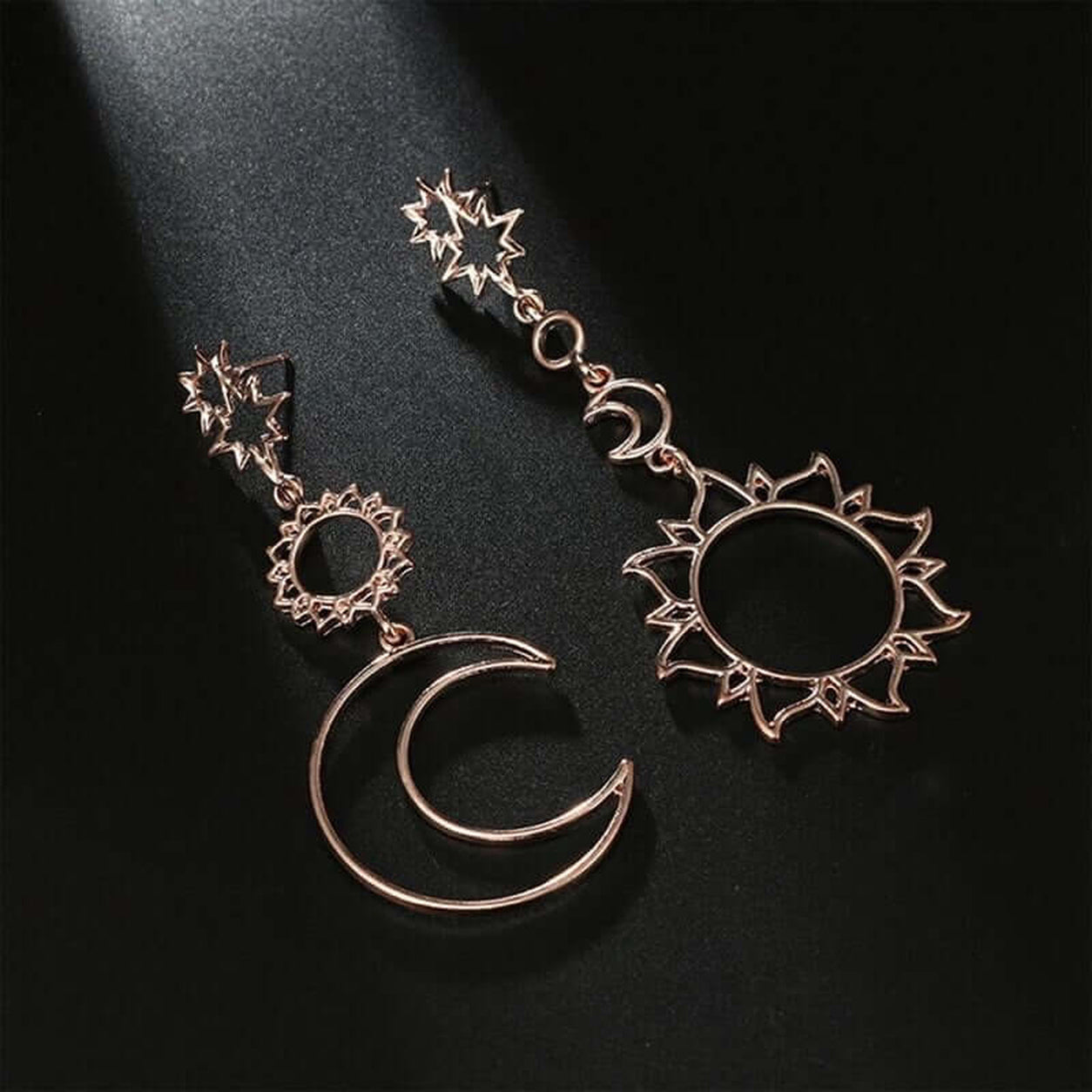 Gold Celestial Wanderer Earrings featuring mismatched sun and crescent moon celestial dangle earrings on black background.