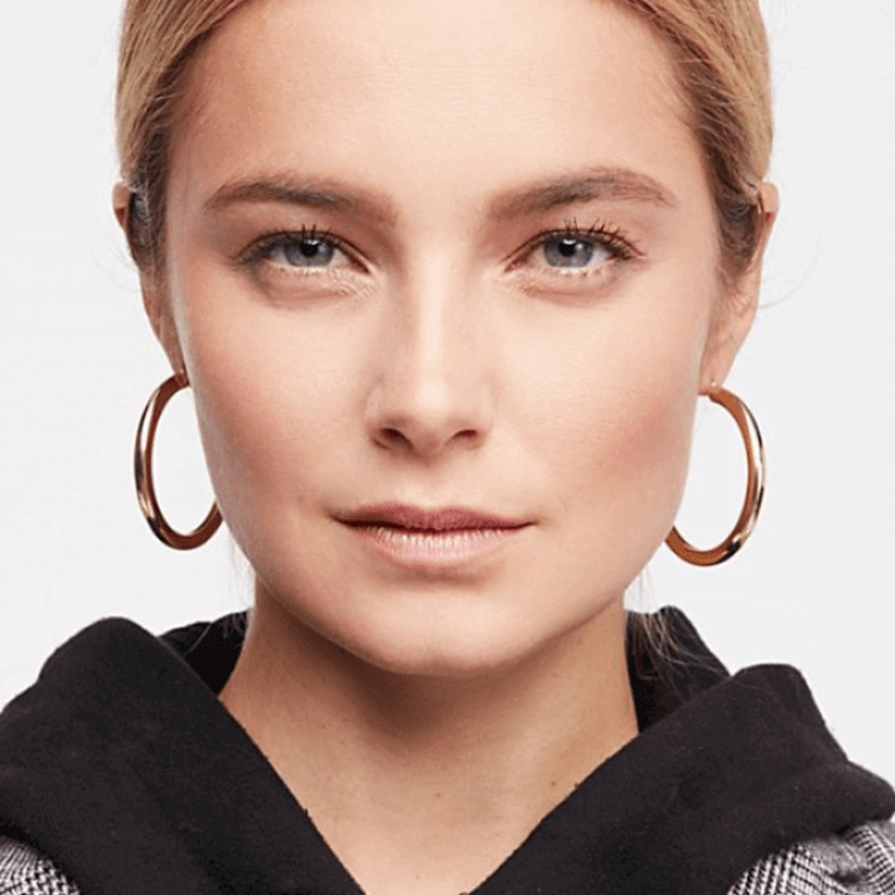 Woman wearing Classic Hoop Earrings in polished gold with a timeless minimalist design.