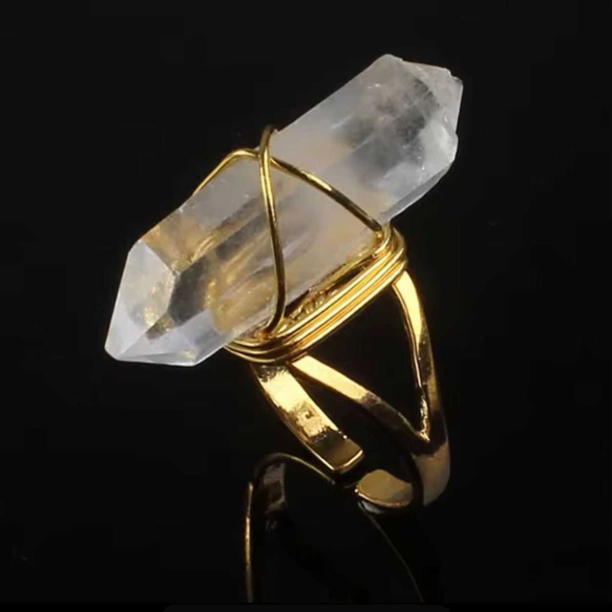 Gold Clear Quartz Crystal Ring displayed on a black background highlighting the natural quartz crystal and adjustable band.