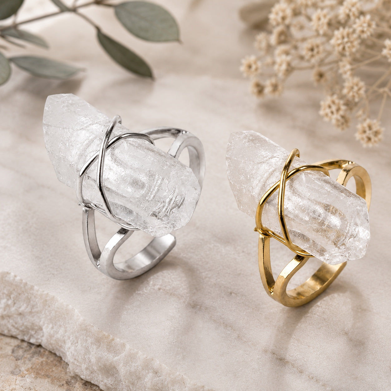 Clear Quartz Crystal Ring available in gold and silver finishes displayed on a natural stone surface.