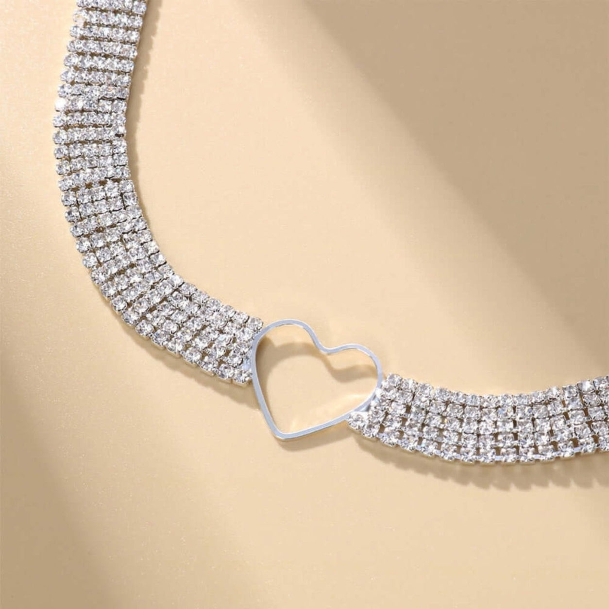 Close-up of the Crystal Heart Choker Necklace with a silver-tone open heart charm and five rows of sparkling rhinestones.
