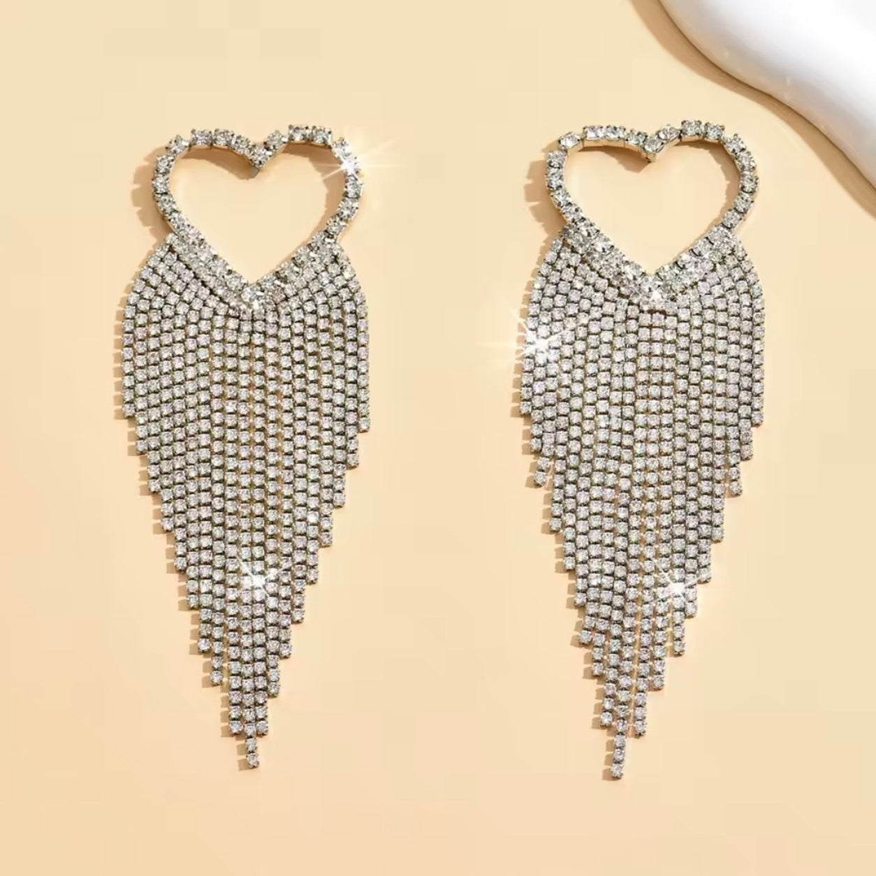 Crystal Heart Dangle Earrings in silver with sparkling rhinestone heart tops and cascading crystal fringe statement design.
