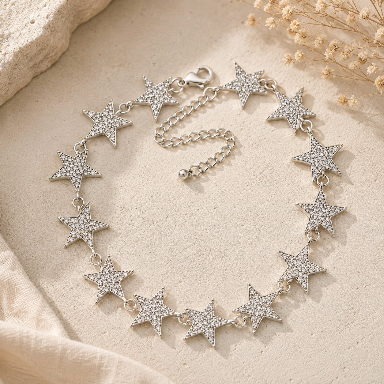 Silver Crystal Star Collar Necklace with crystal pavé stars displayed on a neutral stone background for modern celestial jewelry styling.