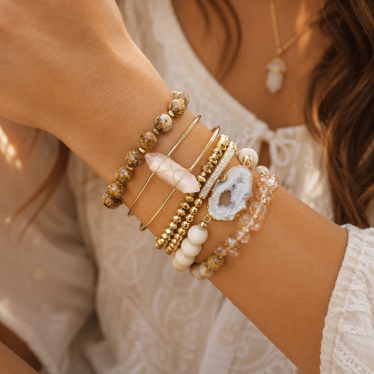 Model wearing the Crystal & Stone Bracelet Stack featuring gold bangles, natural stone beads, rose quartz, druzy, and crystal bracelets.