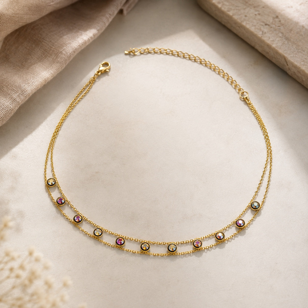 Dainty Gems Choker Necklace with double gold chains and colorful iridescent crystal accents displayed on a neutral background.