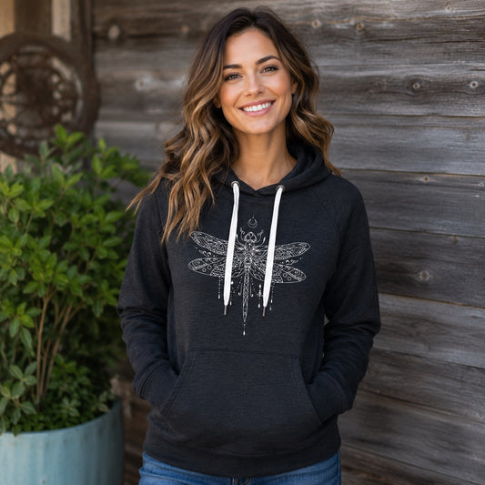 Woman wearing the Dragonfly Hoodie featuring a white boho dragonfly design on a black pullover hoodie.