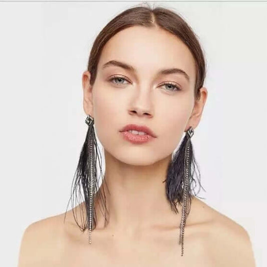 Model wearing Elegant Feather Earrings in black with crystal studs, soft feathers, and cascading chain accents.
