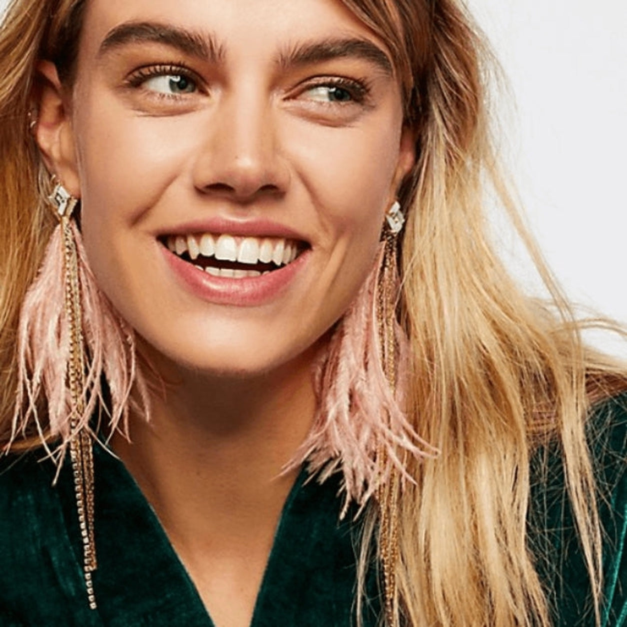 Model wearing Elegant Feather Earrings in pink with sparkling crystal studs, soft feathers, and delicate chain accents.