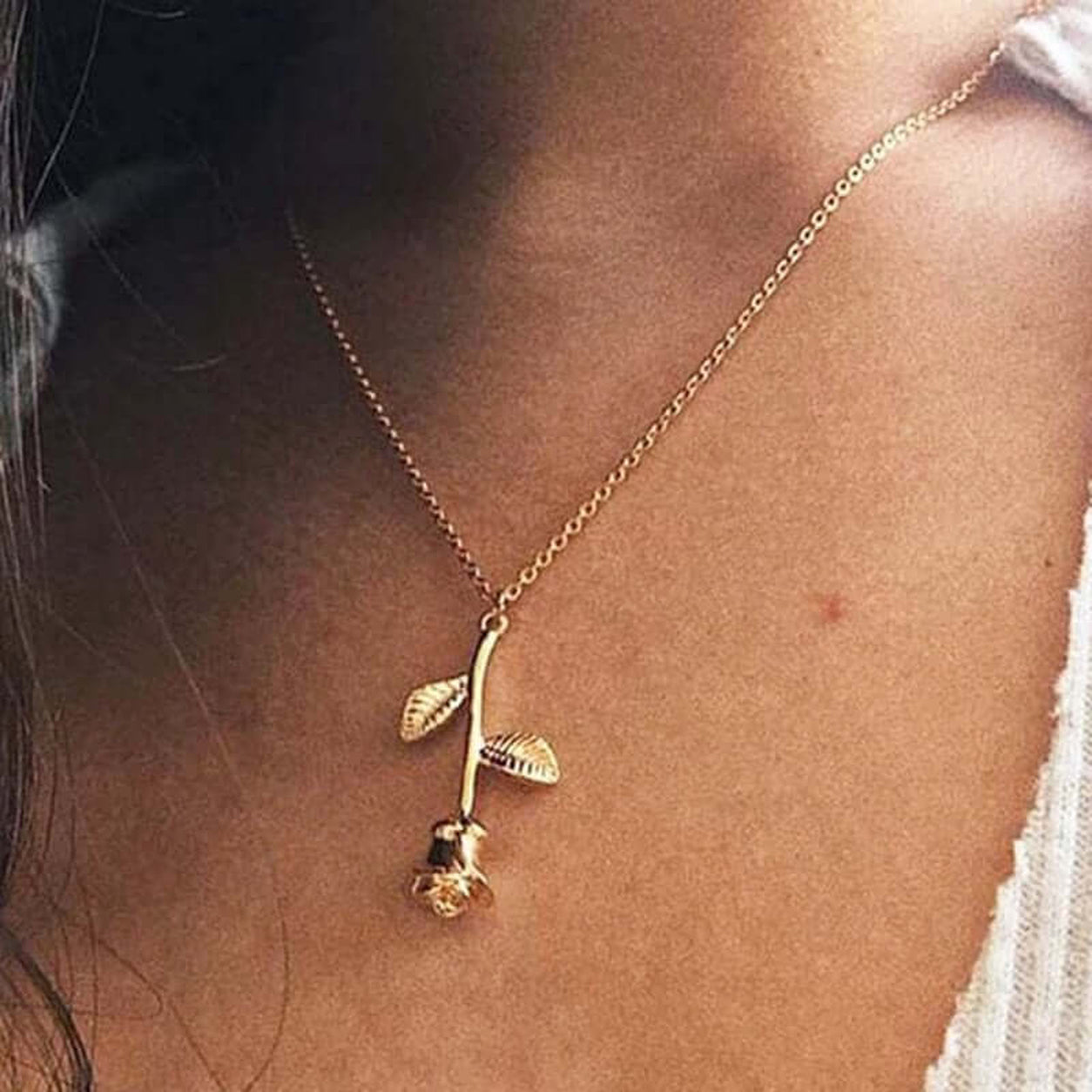 Elegant Rose Pendant Necklace in gold worn on a fine chain with a minimalist floral design.