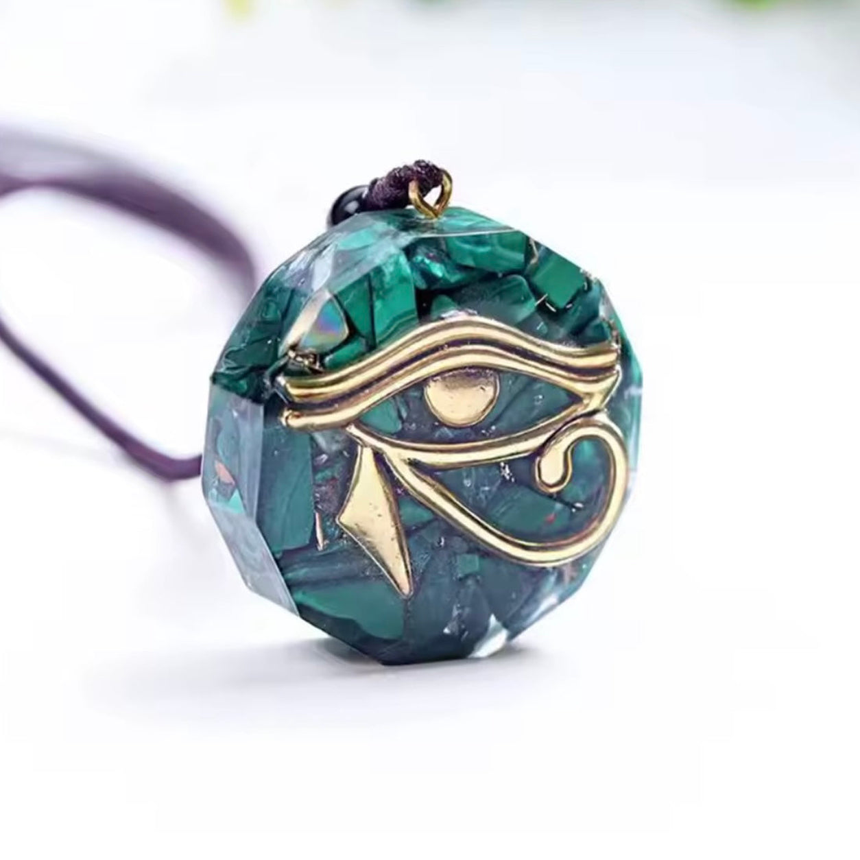 Angled view of the Eye of Horus Malachite Pendant Necklace highlighting the faceted gemstone, polished finish, and gold symbolic design.
