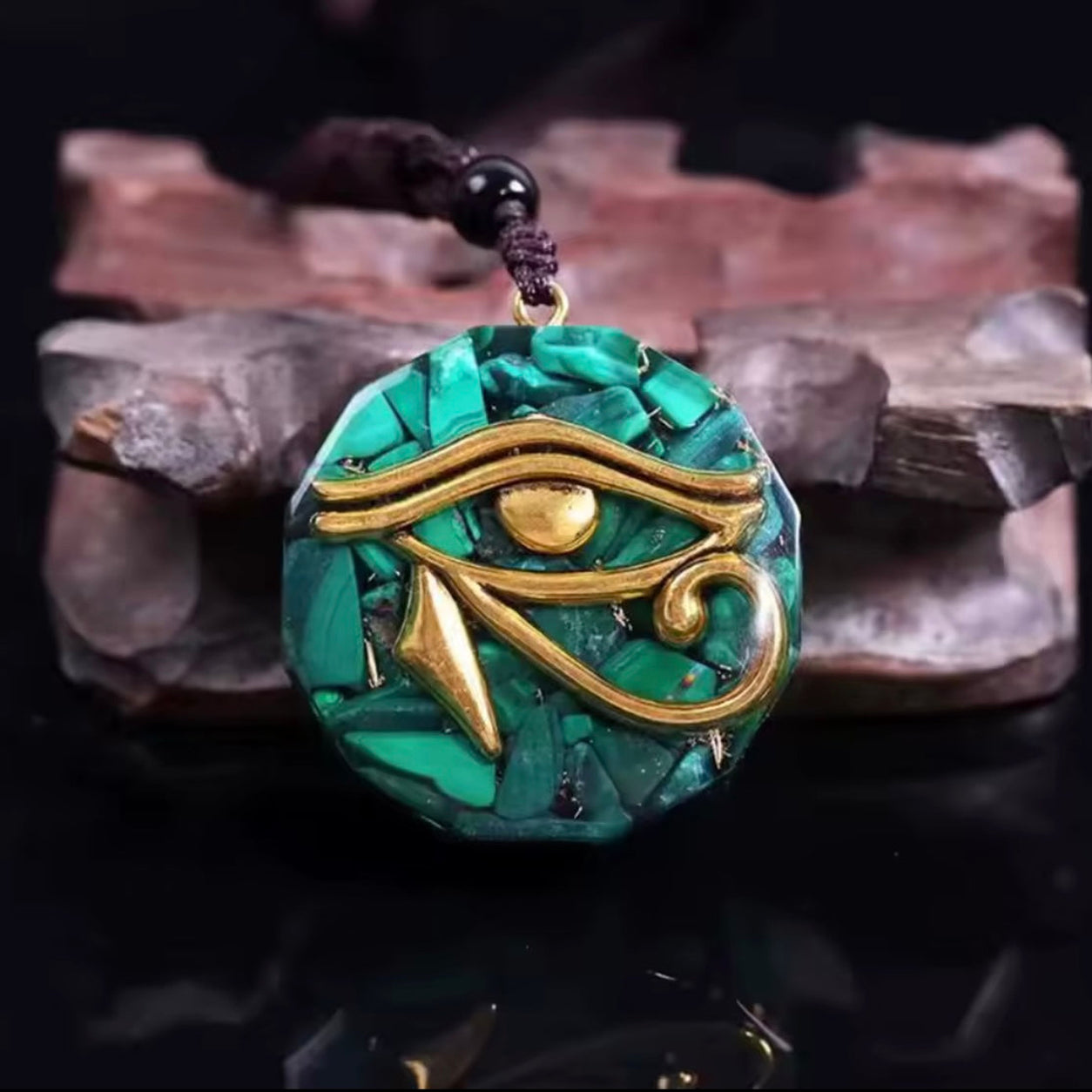 Close-up of the Eye of Horus Malachite Pendant Necklace with rich green malachite patterns and detailed Egyptian Eye of Horus centerpiece.