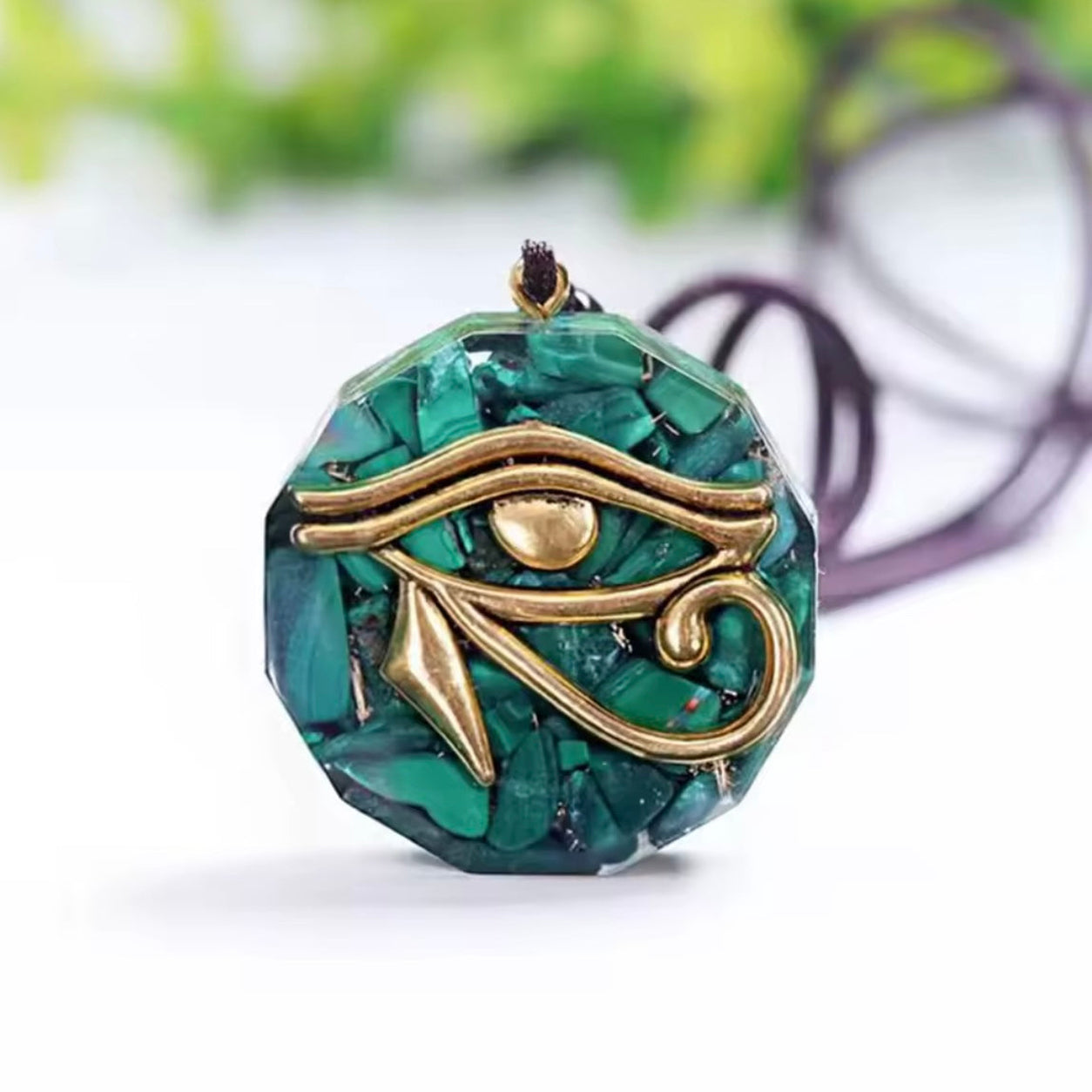 Eye of Horus Malachite Pendant Necklace featuring natural green malachite in a faceted round pendant with gold Egyptian eye design.