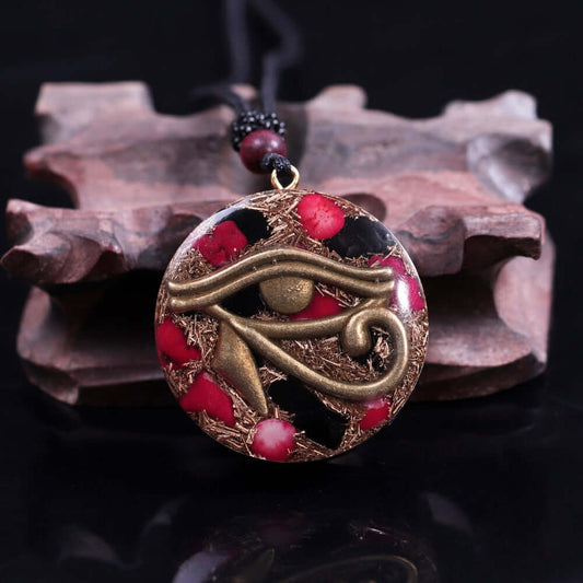 Eye Of Horus Pendant Necklace featuring a bronze Eye of Horus symbol with red coral accents in a handcrafted round resin pendant on black background.