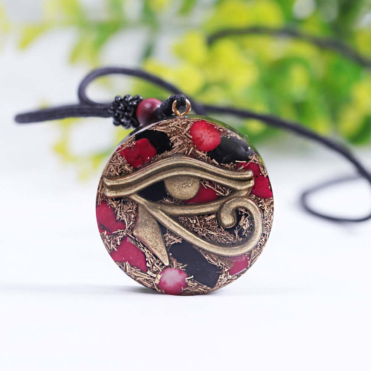 Front view of the Eye Of Horus Pendant Necklace with bronze Egyptian Eye of Horus symbol, red coral details, and adjustable black cord.