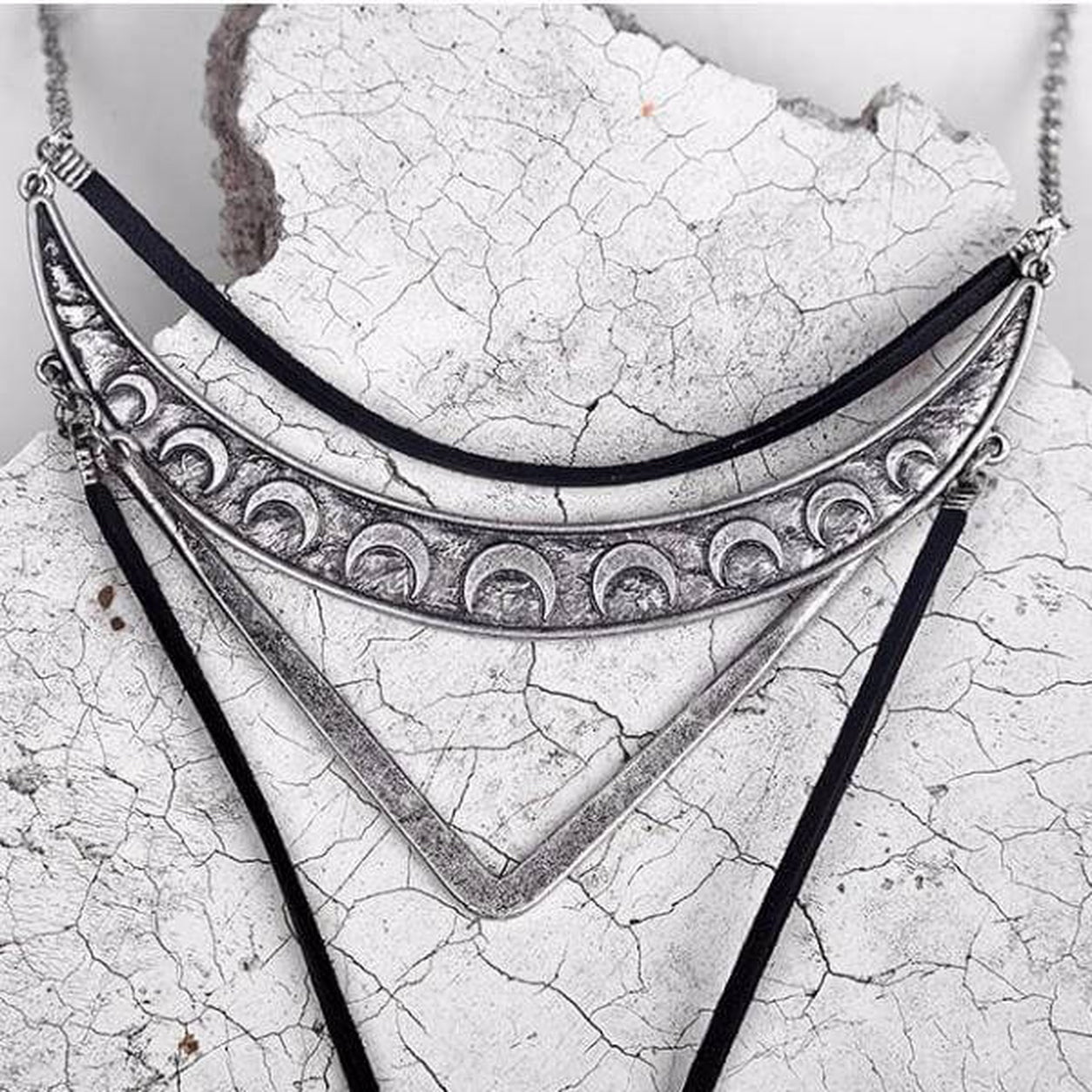 Silver Geometric Bolo Necklace featuring layered geometric pendants with crescent moon design and black cord.