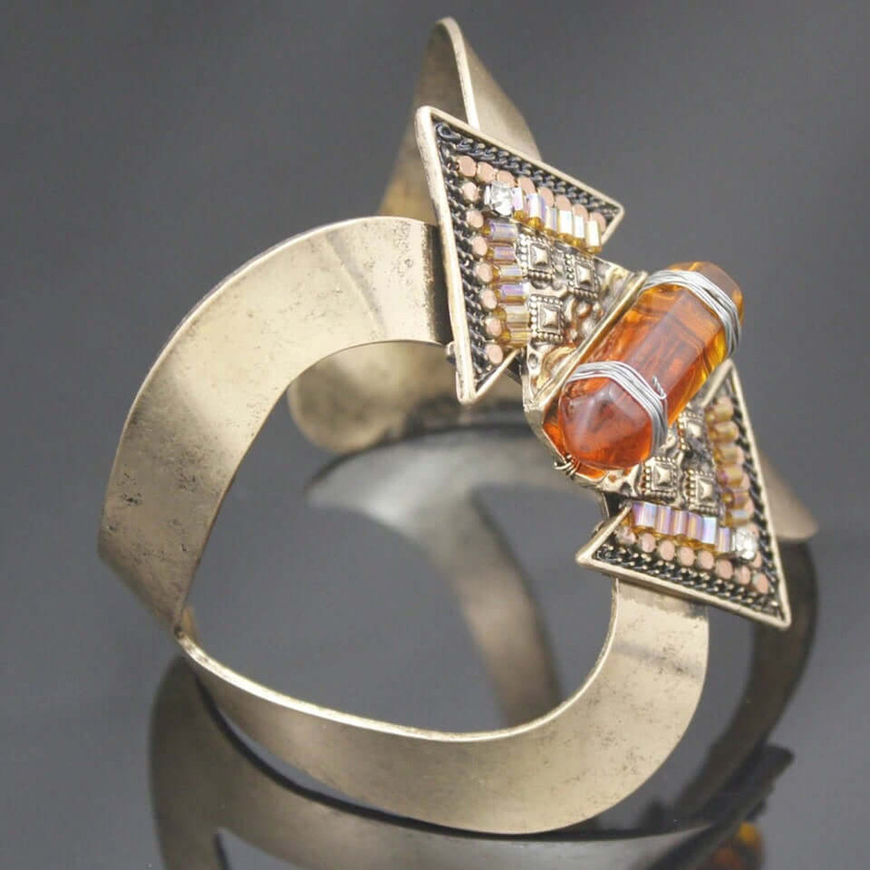 Side angle of the Geometric Crystal Cuff Bracelet showcasing the wide cuff design, geometric details, and amber crystal centerpiece.