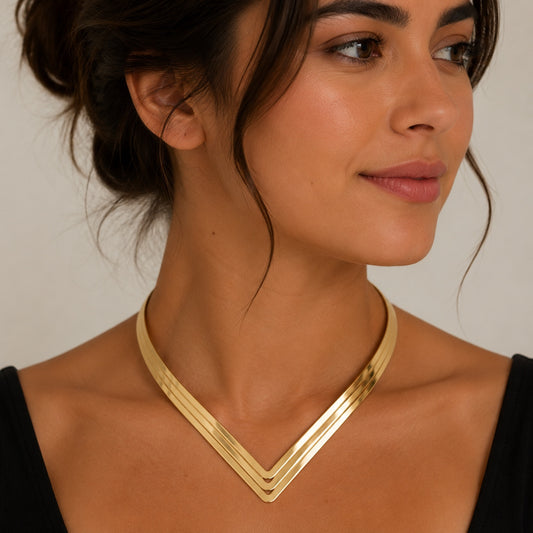 Woman wearing a gold Geometric Torque Collar Necklace with a polished V-shaped geometric collar design.