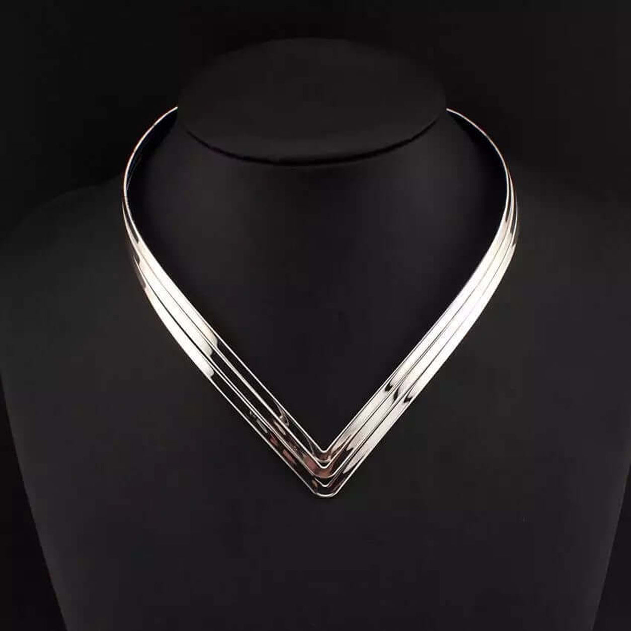 Silver Geometric Torque Collar Necklace presented on a black display bust with a polished geometric finish.