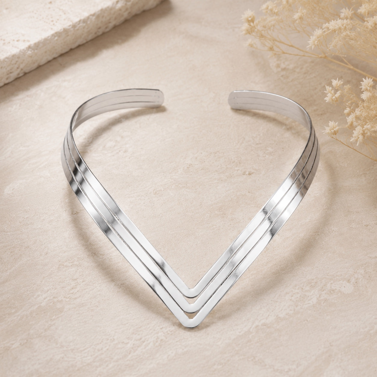 Silver Geometric Torque Collar Necklace displayed flat to showcase its modern open collar construction.