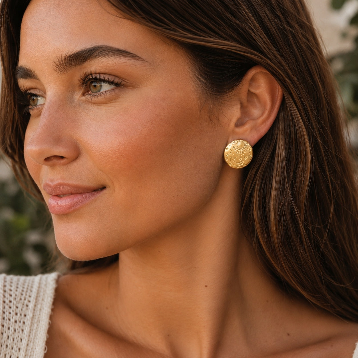 Woman wearing gold Celestial Stud Earrings with sun, moon and star design.