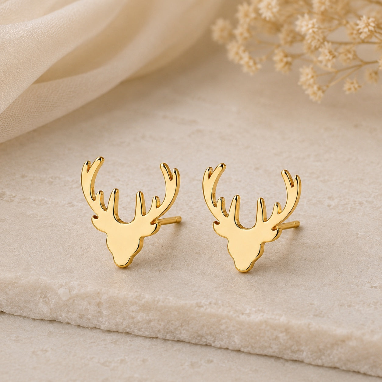 Gold deer antler earrings featuring a minimalist woodland design.