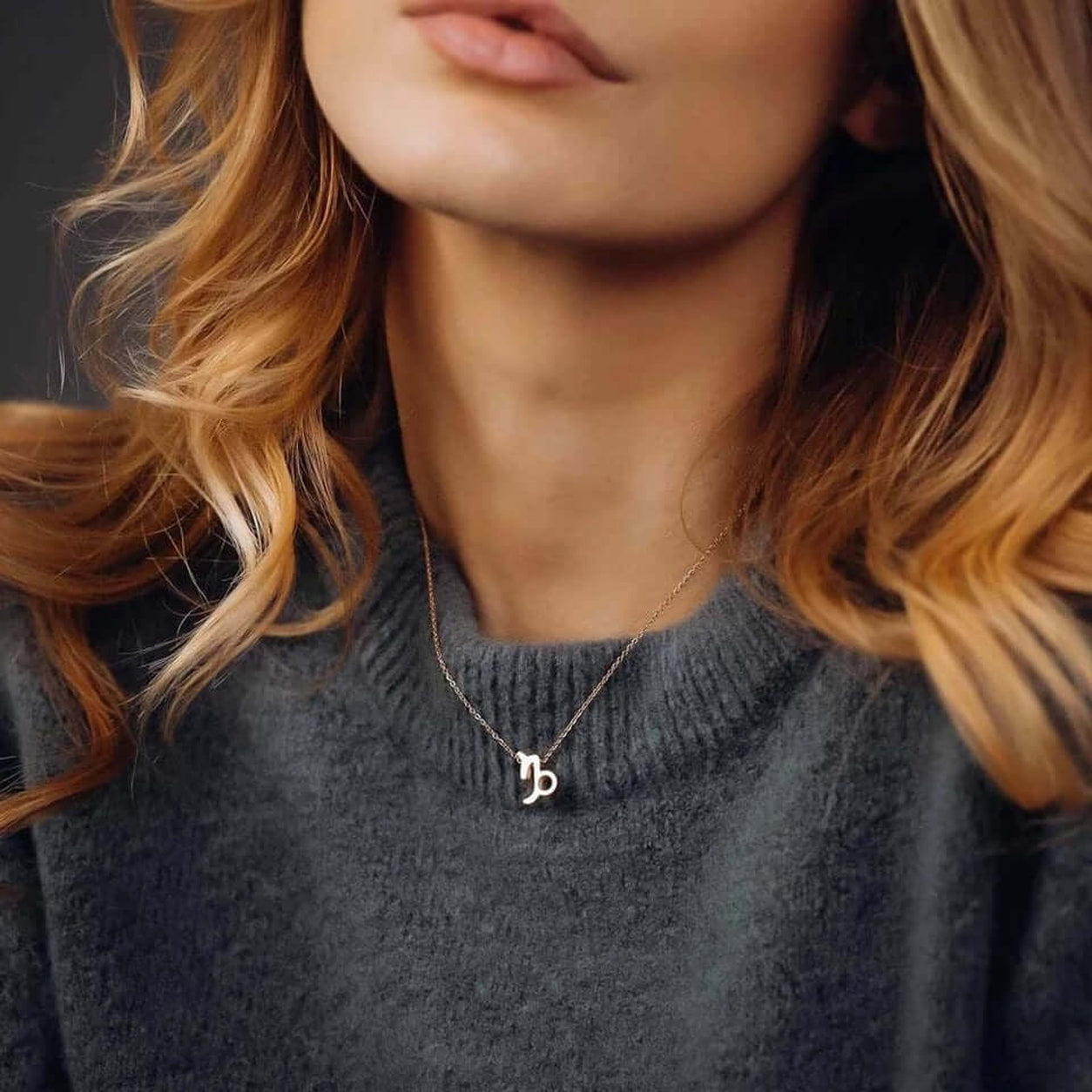 Woman wearing Gold Zodiac Necklace with Capricorn zodiac sign pendant.