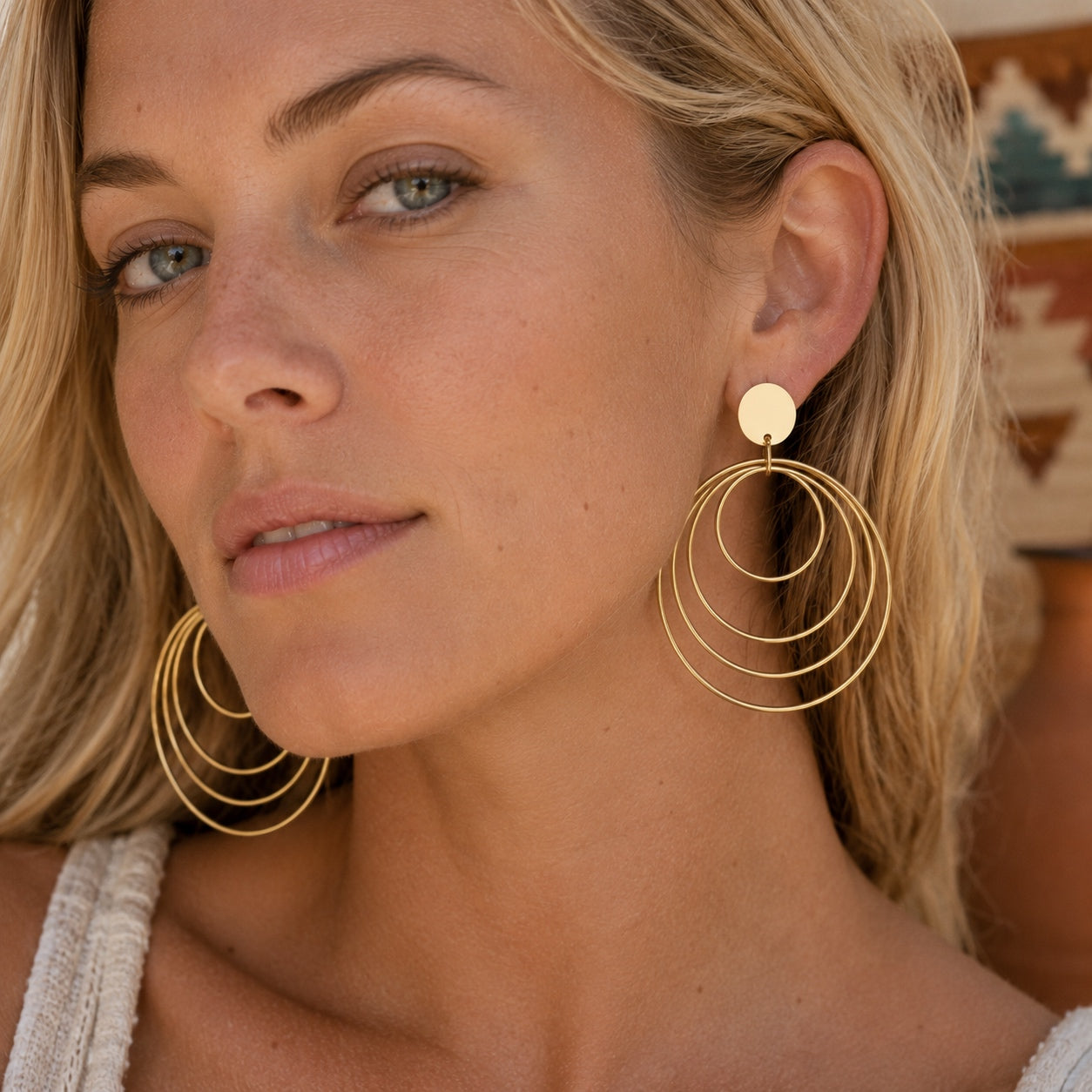 Woman modeling Golden Circles Dangle Earrings with cascading gold circles and a modern boho style.